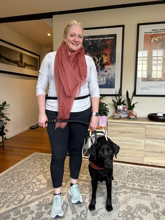 Sophie standing next to her Seeing Eye Dog Winnie, who is seated next to her