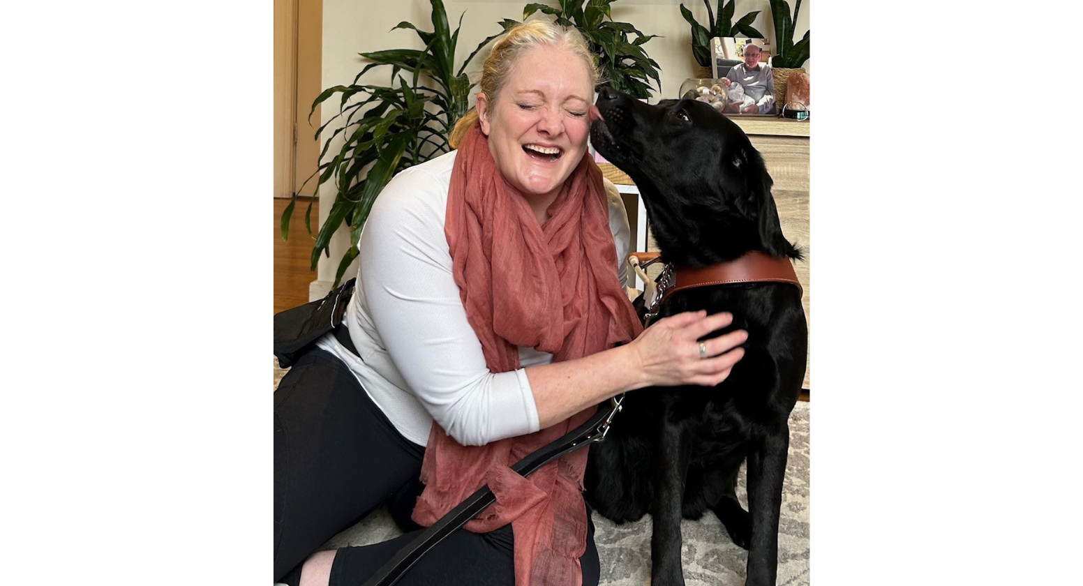 Sophie crouching on the ground with her Seeing Eye Dog Winnie