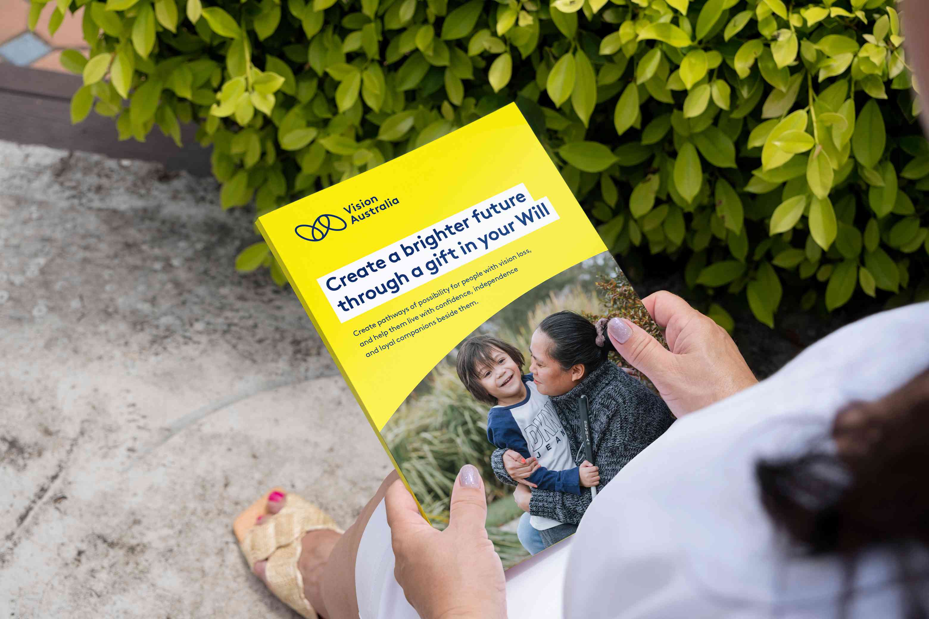 A pair of hands holding the Gifts in Wills brochure