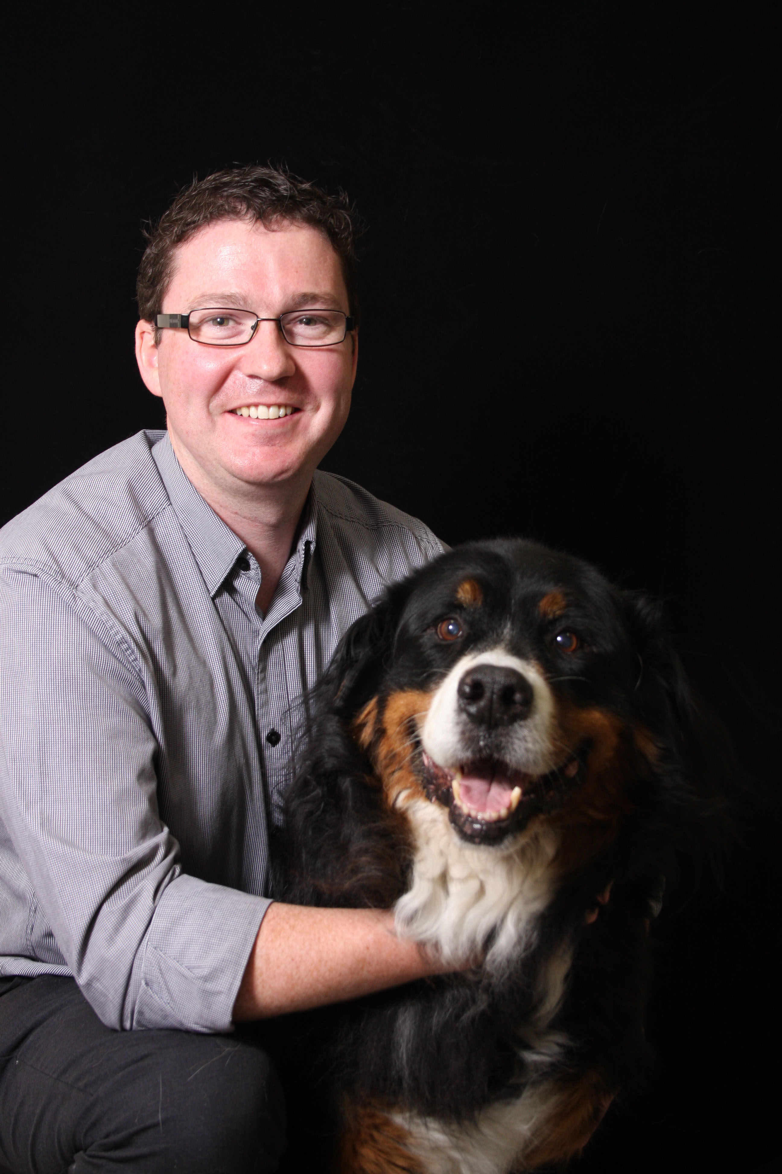 Mina Hamilton smiling at camera and holding a small dog