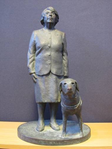 A statue of Mrs P M Gration and a dog sitting next to her