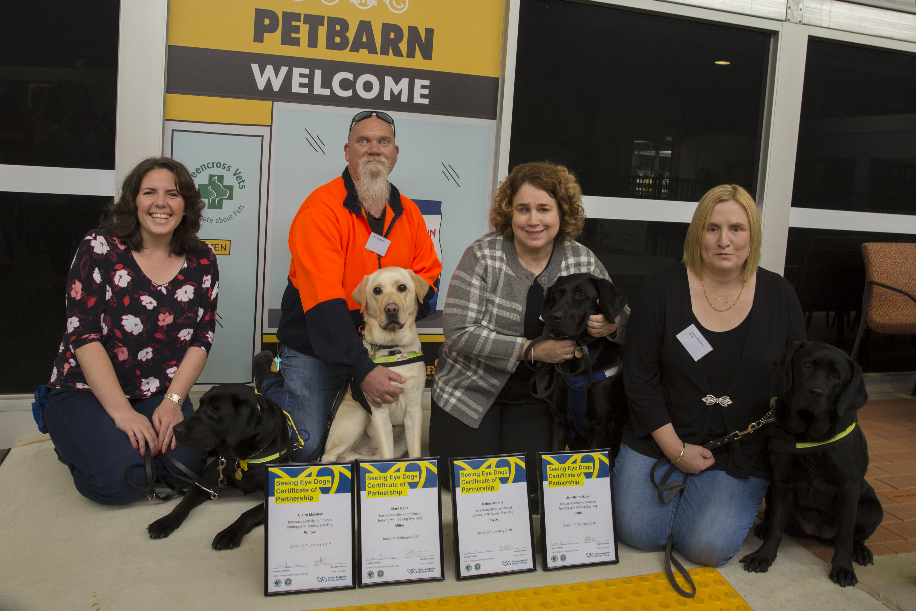 "Claire, Mark, Debra and Jennifer, four of the graduates, crouch with their four Seeing Eye Dogs: Willow, Miller, Royce and Jedda."