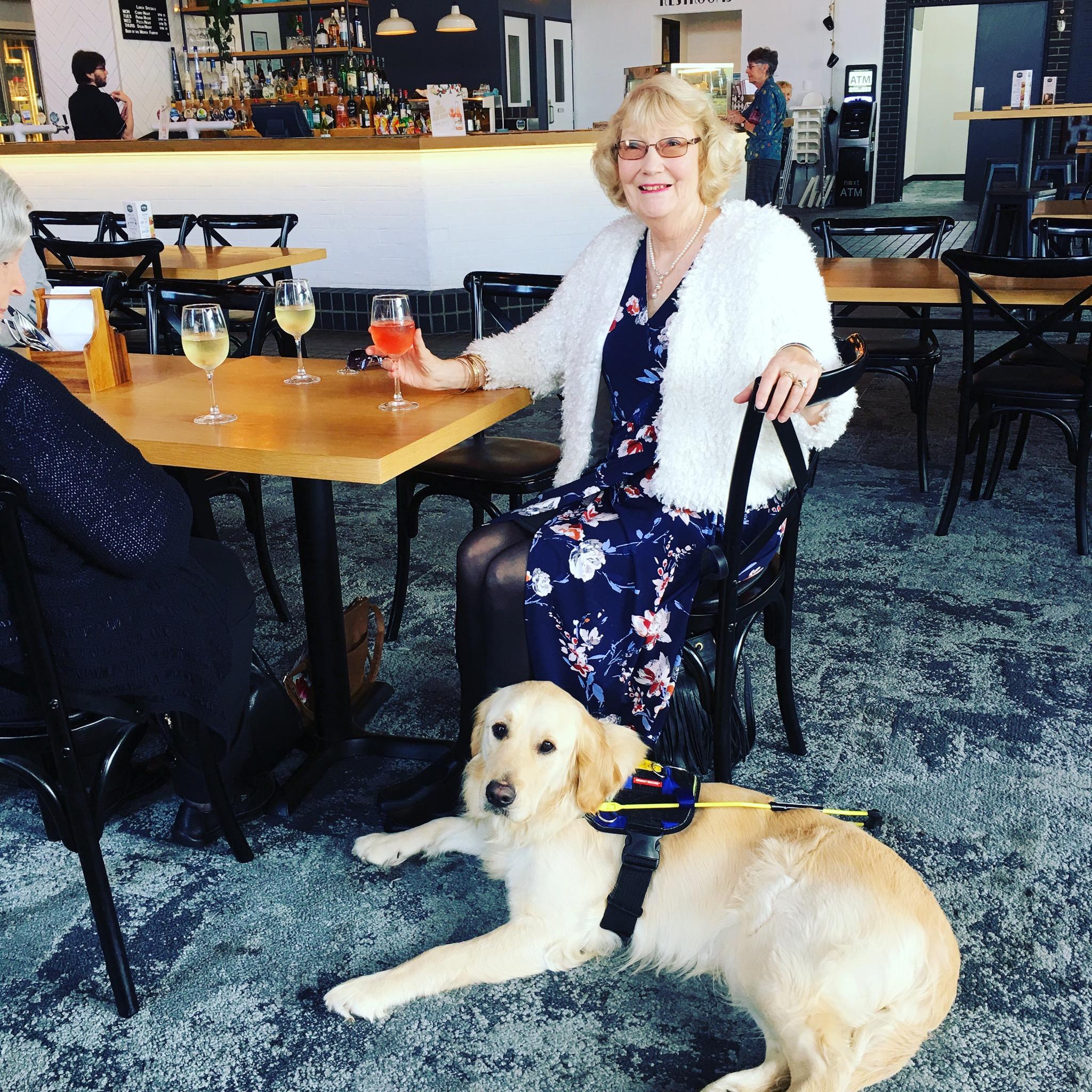 Therese sits at a cafe with Seeing Eye Dog Yael.