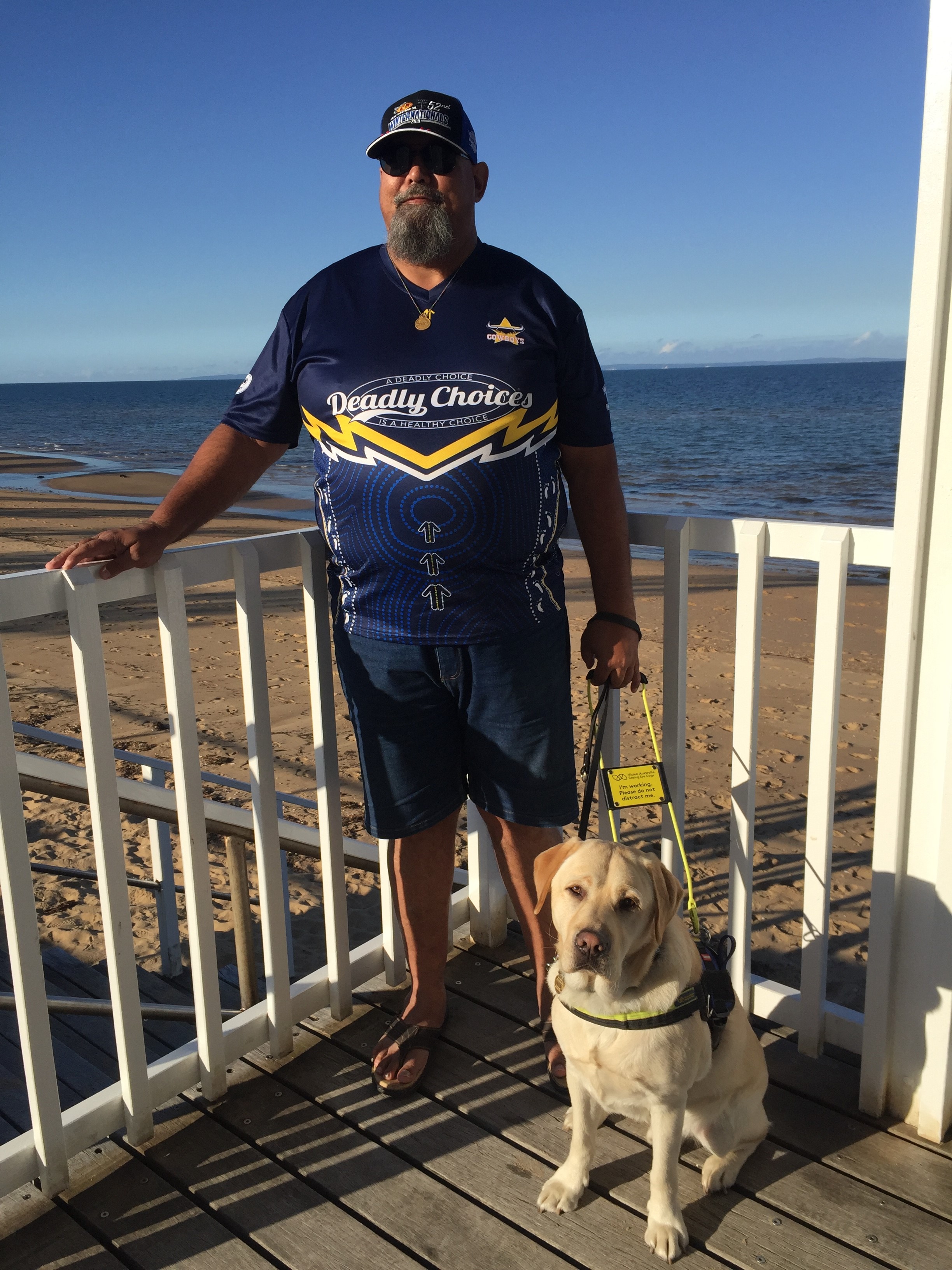 Alan stands on a beach with his Seeing Eye Dog Xenon