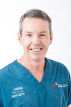 Dr Greg Burton Dr Greg Burton smiles to camera in his blue scrubs
